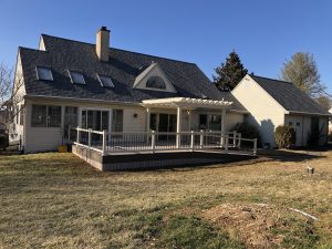Timbertech PVC French White Oak deck with American Walnut border, ramp to grade, matching skirting, almond vinyl railings and pergola &#8211; Chester County PA