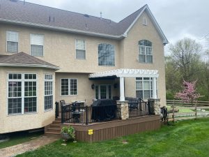 Timbertech PVC English Walnut deck with matching skirting, white composite pergola with stone pillars