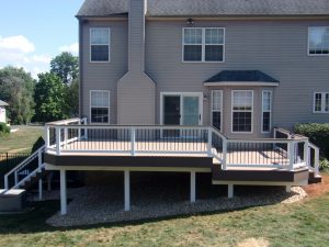 Azek Brownstone deck with American Walnut border and drink rail, posts & beams covered with white vinyl – Aston PA