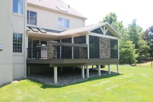 Azek American Walnut deck, A-frame screen room with open gable, gas fireplace. custom bartop on railing and stone columns – Bluebell PA